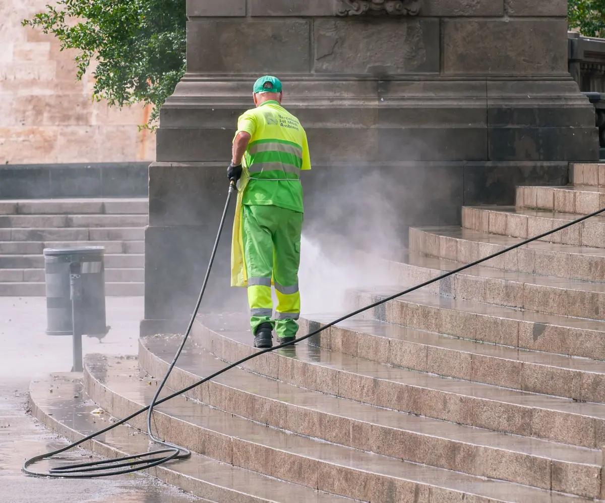 Pressure washing the stone steps outside a public building